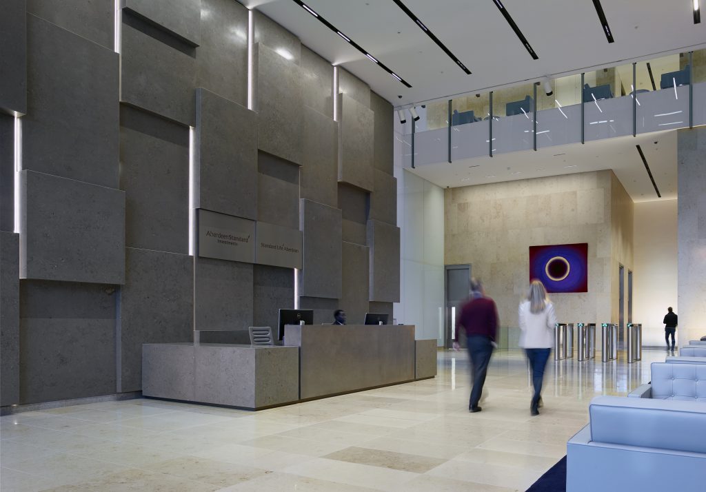 Close-up of Standard Life Edinburgh internal lightweight stone cladding featuring side-lit monolithic stone block elements across the facade.