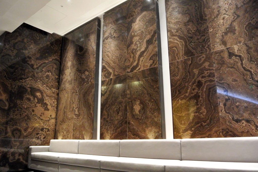 Internal cladding in Air Canada Maple Lounge around seating area featuring Canadian limestone with deep brown tones and wood-like appearance