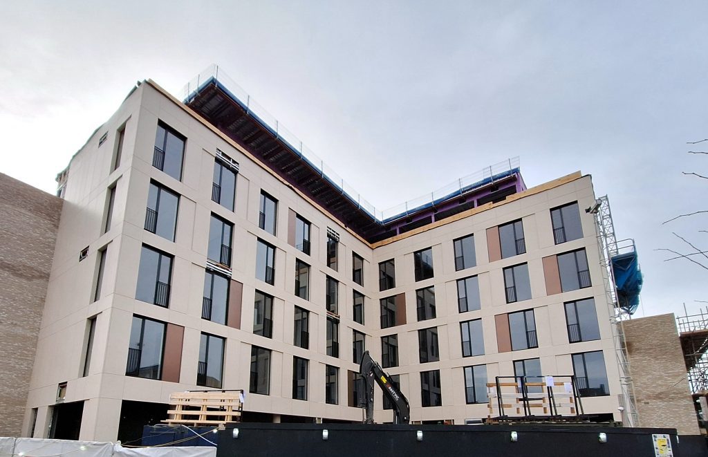 Hazel Court project with porcelain facade panels, bronze steel decorative panels, windows, and construction elements midway through installation.